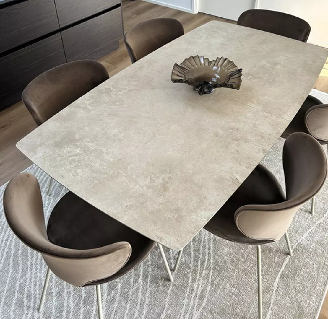 Blagovaonica koja se nastavlja na kuhinju odiše neutralnim tonovima, a zaobljena forma stolaca ublažava rubove stola