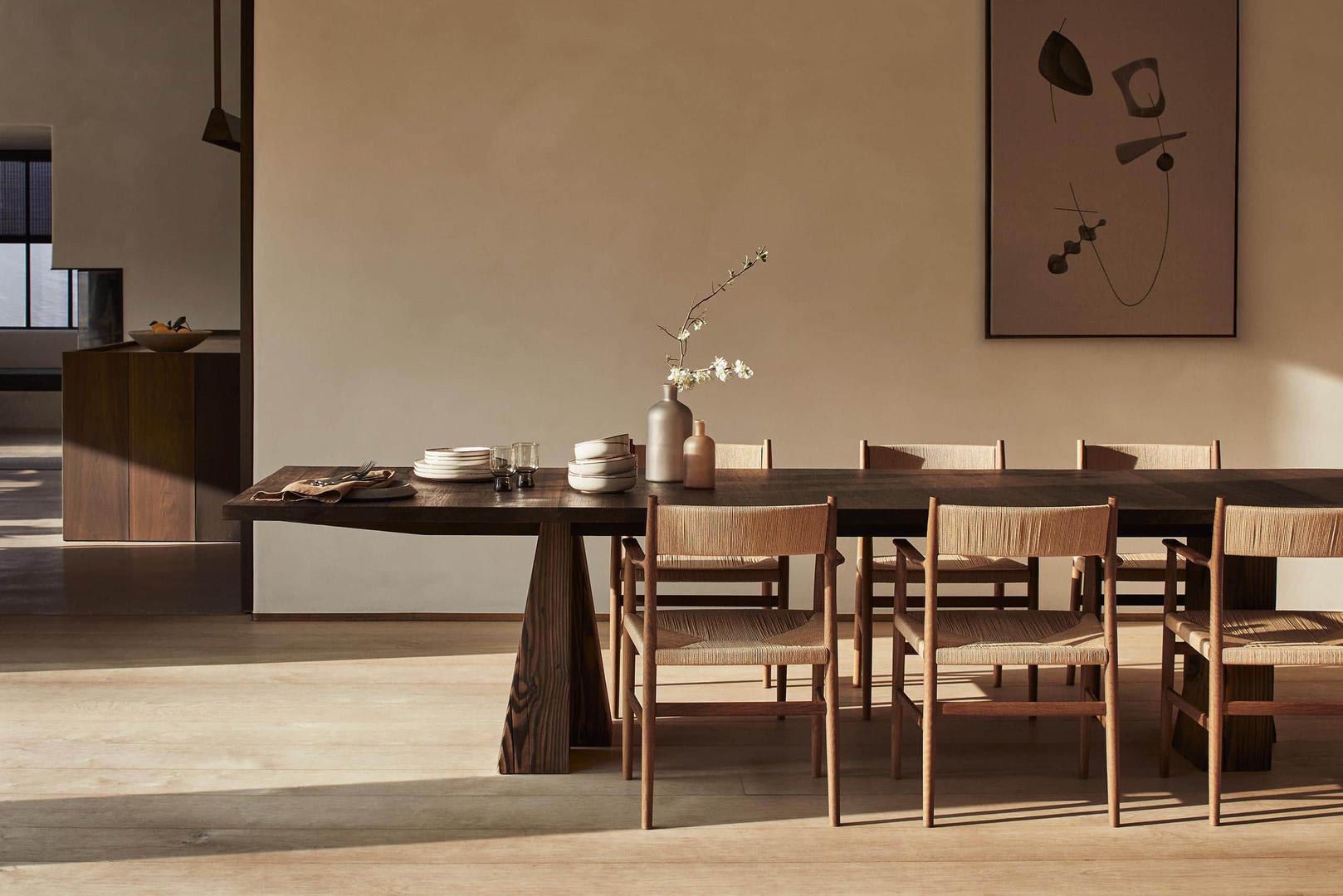 Prostranom blagovaonicom dominira raskošni blagovaonski stol okružen kontrastnim drvenim stolcima