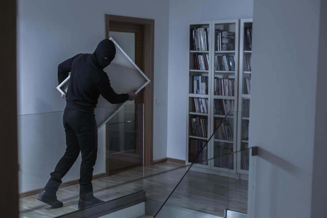 Image of robber in black mask stealing picture